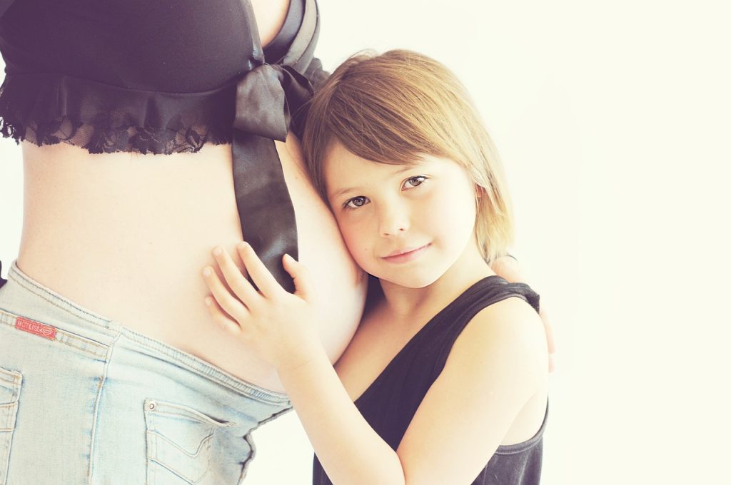 A woman and a little girl embrace each other warmly, showcasing a moment of love and affection between them