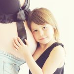 A woman and a little girl embrace each other warmly, showcasing a moment of love and affection between them