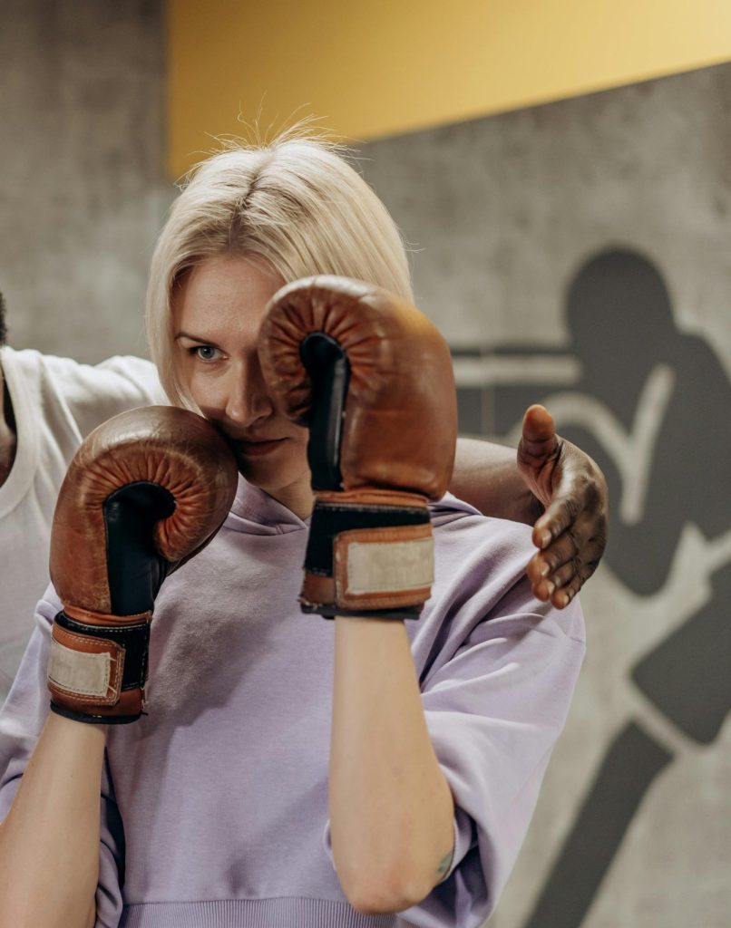 pexels-photo-6740346-6740346 Boxing coach instructing a focused female trainee in a gym setting. Intense training moment captured.