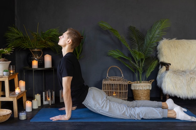 A man practicing yoga in front of a fireplace, blending relaxation with the warmth of the flickering flames